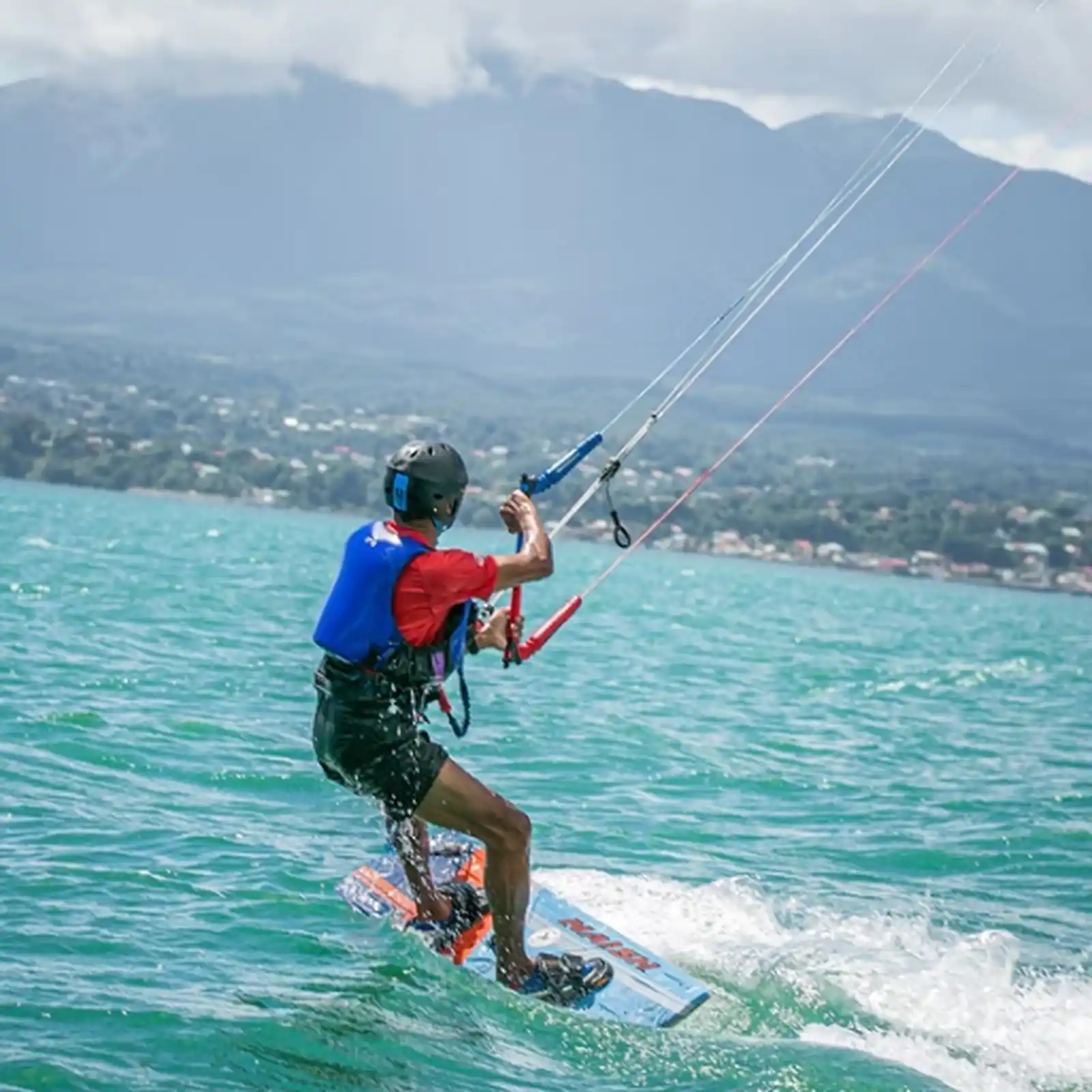 Kitesurfer en progression sur un spot de Guadeloupe avec vue sur les montagnes