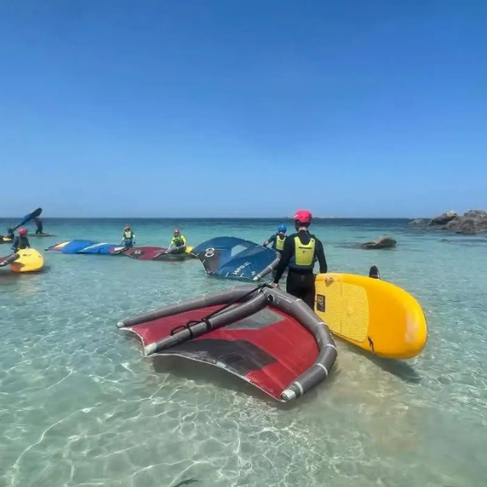Cours de wingfoil Natural Advent en Bretagne avec planches et wings sur l’eau turquoise