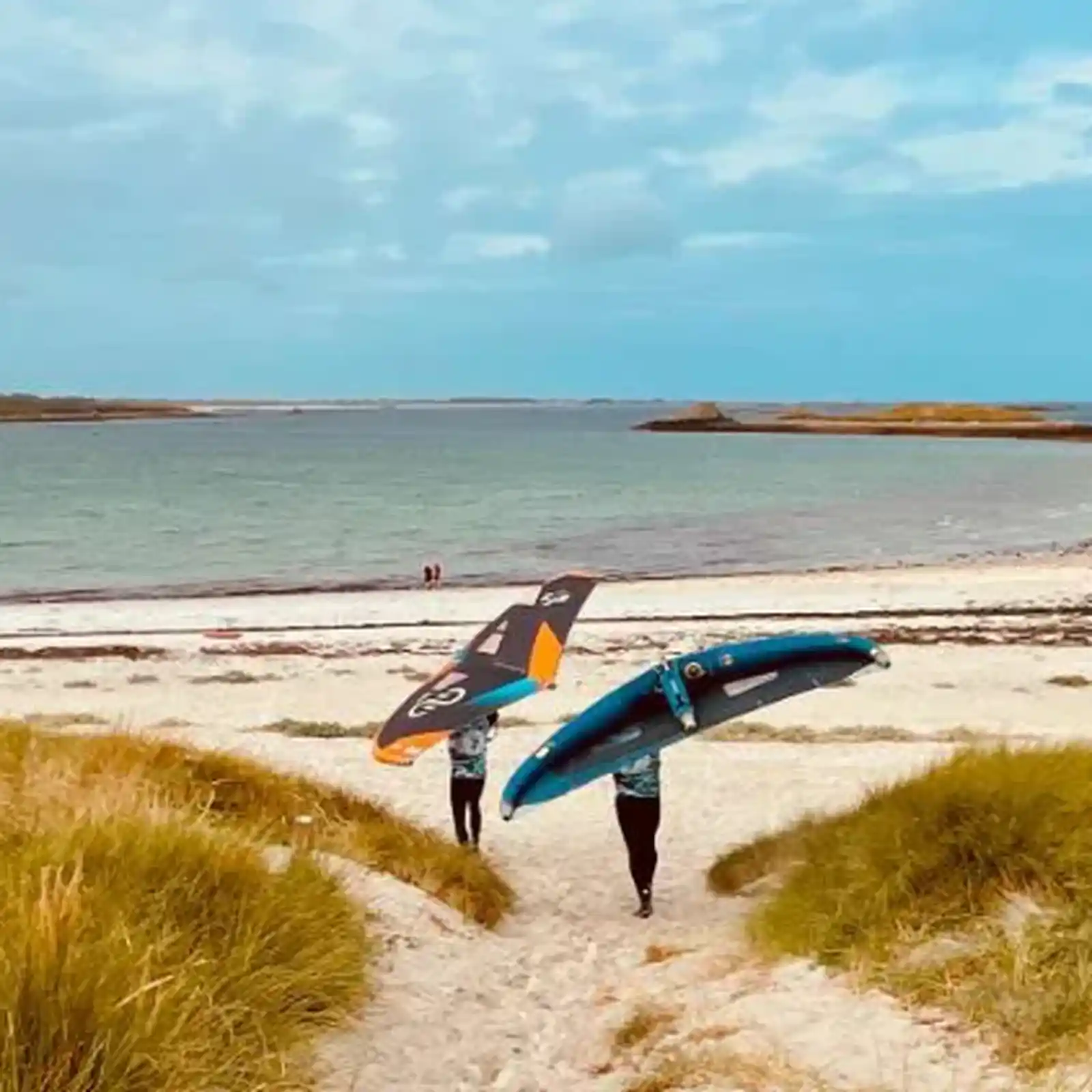 Riders Natural Advent transportant leurs wings sur une plage sauvage en Bretagne