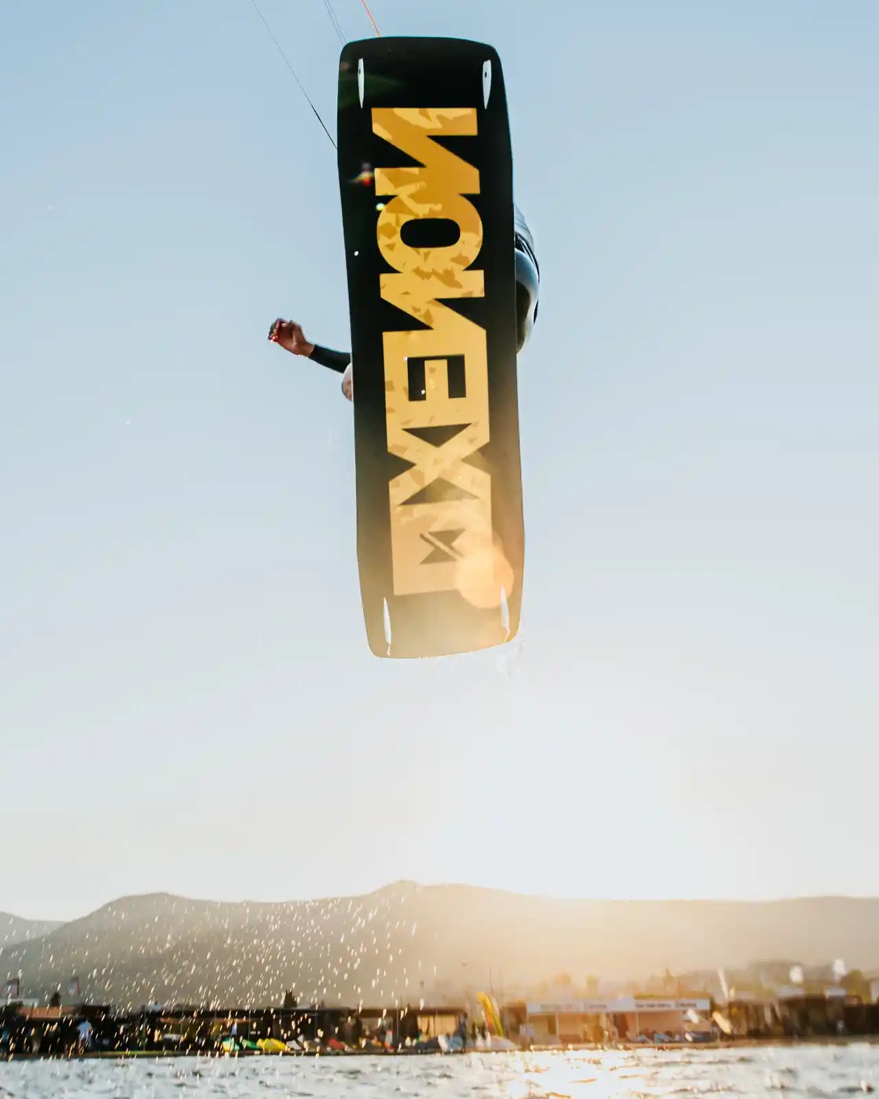 Rider en kitesurf réalisant un saut avec la planche Xenon Plank 2026 au coucher du soleil